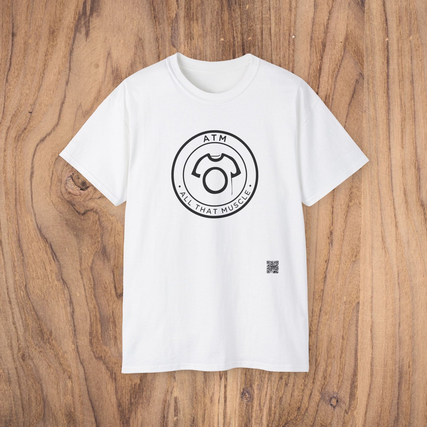 White t-shirt with black circular logo on a wooden surface